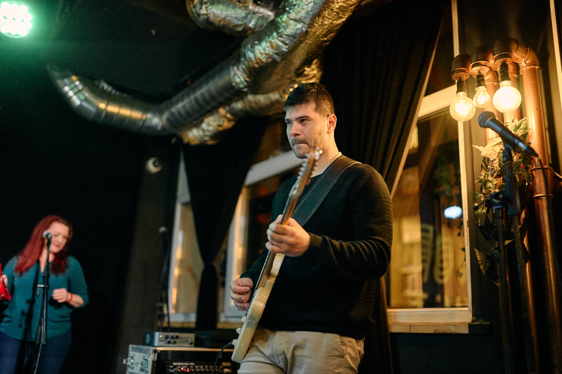 David Žagar svira gitaru pod svjetlima pozornice